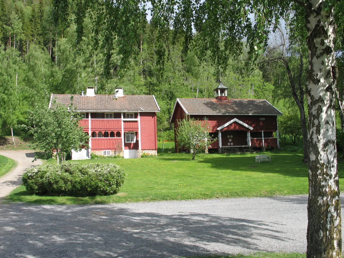 Gårdstunet på Eidsalm med de røde driftsbygningene en sommerdag.